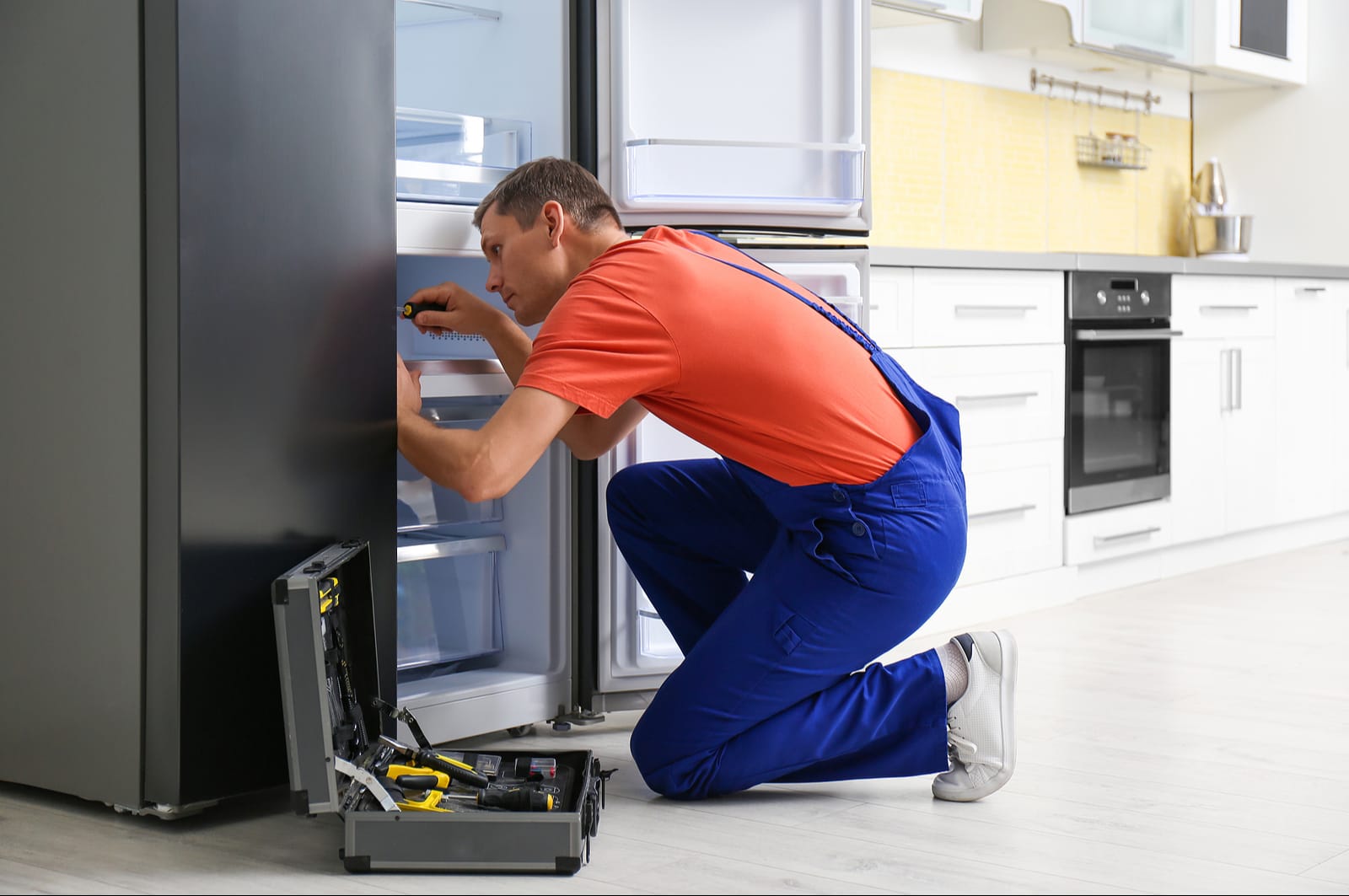 Technician servicing the inside of a refrigerator